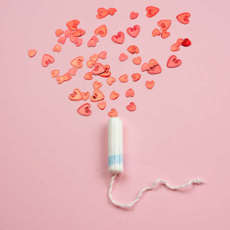 Medical female tampon on a pink background. Hygienic white tampon for women. Cotton swab. Menstruation, means of protection.の写真素材