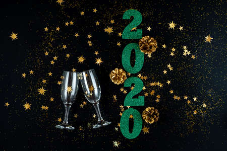 Green numbers 2020 New Year, cups, gold cones, and gold stars on a festive black backgroundの写真素材