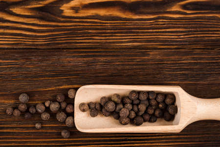 Spices, black pepper lie on wooden backgroundの写真素材