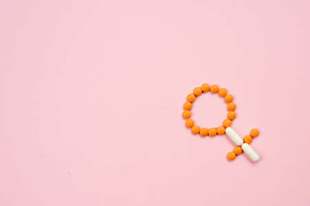 Woman pills for period pain lying on  pink  background. Gender symbol. Female sign.  - Imageの写真素材