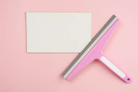 Window brush lying on empty white mockup on pink background. Concept cleaning serviceの写真素材