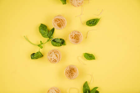 Pasta and basil closeup. Top view.On the yellow background.の写真素材