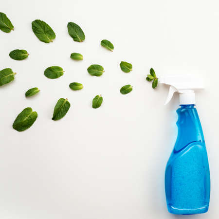 Detergent blue bottle with white  cap  on a white background spray a fresh mint leavesの写真素材
