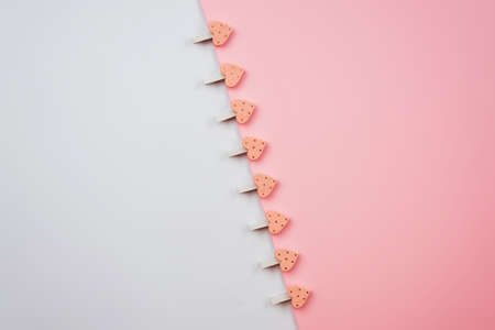Clothespins with hearts on a white pink background. Festive concept in minimal style for Valentine's Day or another love event.の写真素材