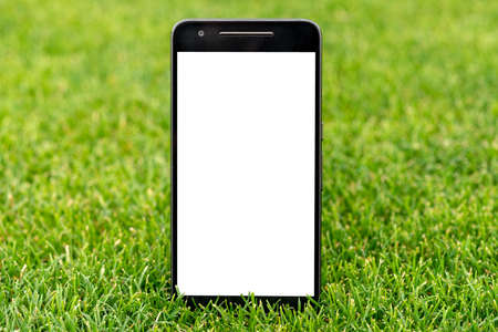 Mobile smart phone mockup with white screen on green grass background. Highly detailed illustration.の写真素材