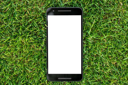 Mobile smart phone mockup with white screen on green grass background. Highly detailed illustration.の写真素材