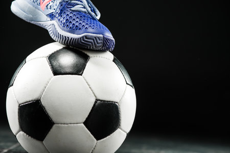 Legs of soccer player with ball on dark backgroundの写真素材