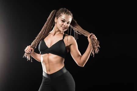 Beautiful female fitness model on black background