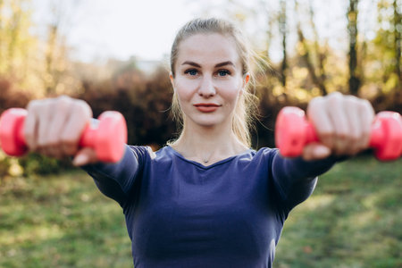 Beautiful young woman working exercise with dumbbells, as a part of her lifestyle.の写真素材