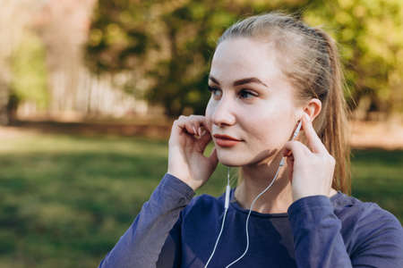 Sports girl in headphones adjusts to trainingの写真素材
