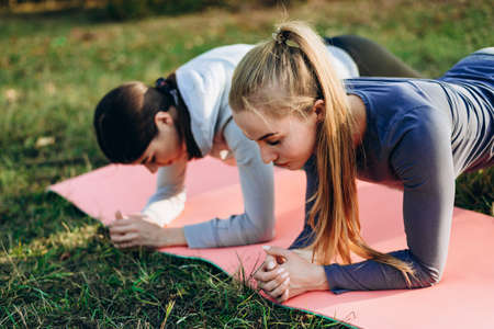 Photo of two adorable girls doing exercises outdoors. Sports strapの写真素材