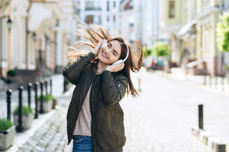 Beautiful smiling girl having fun listening to musicの写真素材