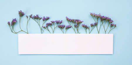 Frame made of  rustic flowers on table. Copy space on blank empty white paperの写真素材