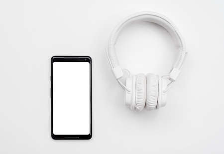 White headphones and smart phone on white backgroundの写真素材