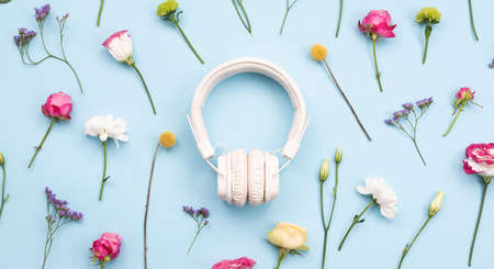White headphones on a blue, floral backgroundの写真素材