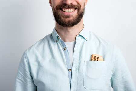 Closeup  crop portrait of happy  bearded man with a comb in his pocketの写真素材