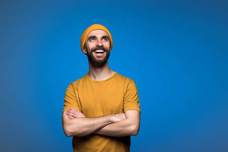 Portrait of handsome young man folded hands and happily  looking upの写真素材