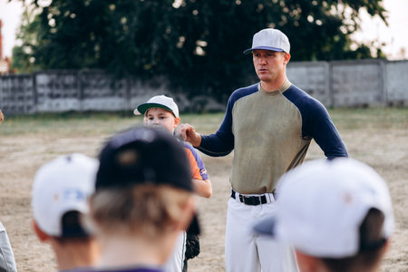 Kyiv, Ukraine - June 3, 2020: A young baseball coach instructs his students before the gameのeditorial素材