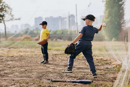 Kyiv, Ukraine - June 3, 2020: Two little brothers playing baseball outdoors