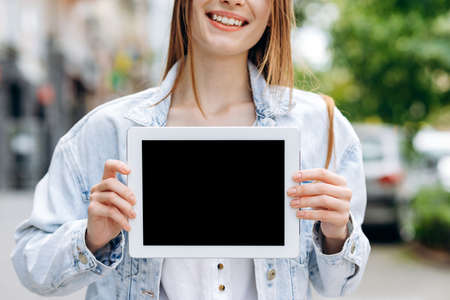Young female student holding a tablet with a blank screenの写真素材