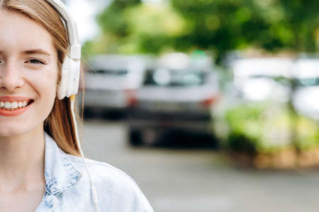 Place for advertising. Half of the face of a pretty girl in headphones outdoorsの写真素材