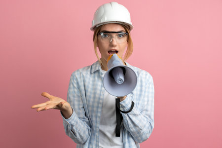Young woman girl posing isolated on pastel pink wall background studio portrait. People sincere emotions lifestyle concept. Mock up copy space. Scream in megaphoneの写真素材