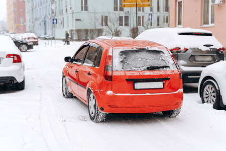 City street covered by snow after blizzard. Parked cars in the street on a snowstorm winter day. Cyclones conceptの写真素材