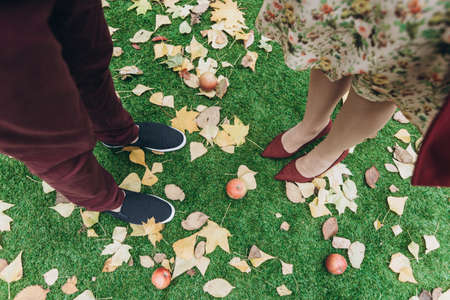 Cropped view of the couple man and woman in love standing outdoor with autumn leaves on background. Lifestyle and relationships conceptの写真素材