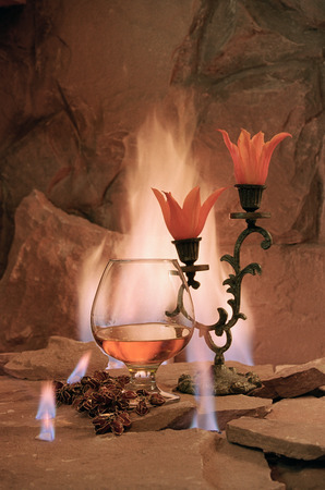 wine glass of brandy on the background of fireの写真素材