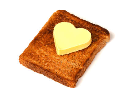 Heart Shaped Butter on wholemeal Toast on white backgroundの写真素材