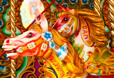 Two Brightly colored carousel horses from a funfairの写真素材