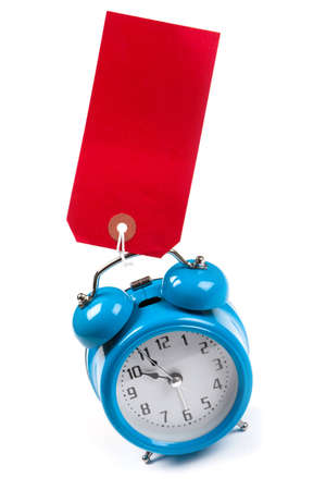 Blue alarm clock with a blank red luggage tag stuck to の写真素材