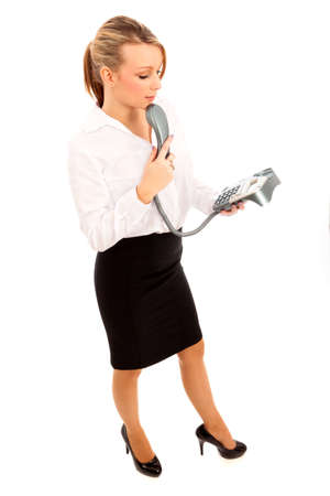 Business Woman in white shirt and black skirt looking thoughtful holding a telephoneの写真素材