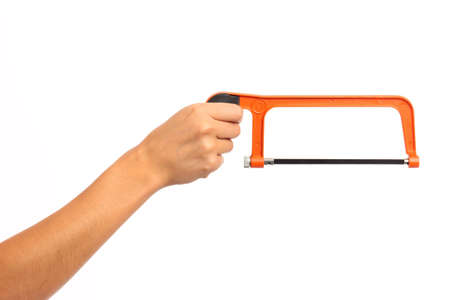 A female hand holding an orange hack saw on white isolated backgroundの写真素材