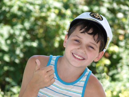 Young boy showing OK and smiling, in captain's peak-capの写真素材