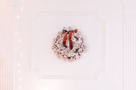 Christmas wreath hanging on the white wallの写真素材