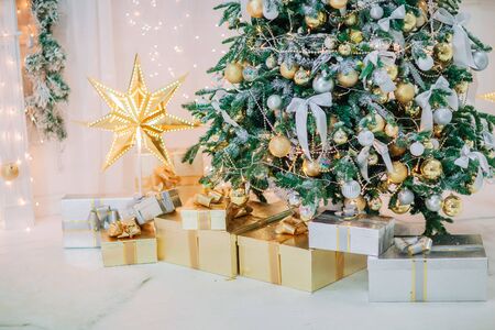 Golden christmas room party decoration. Star, presents, balls, garland and lights.の写真素材