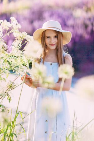 Nice smiling little girl in front of lilac background walking in the parkの写真素材
