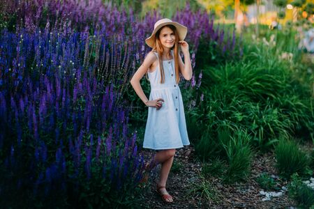 Smiling little girl in white dress in the parkの写真素材