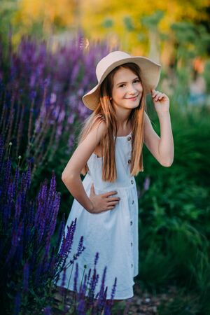 Smiling little girl in white dress in the parkの写真素材