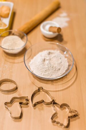 Ingredients for baking, rolling pin, flour in bowls, sugar, vanilla, molds and ceramic forms for...