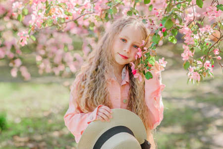 Portrait of nice 10 years old girl in pink apple blooming gardenの写真素材