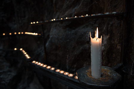 Prayer candles light up the darkness in a churchの写真素材
