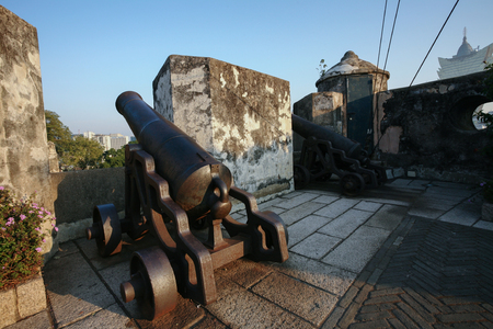 Cannon guarding the battlements of ancient Monte Fort with sunset light in Macau Macao , Chinaのeditorial素材