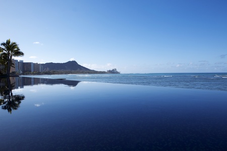 An infinity pool intersects with the beach overlooking Waikiki.の写真素材