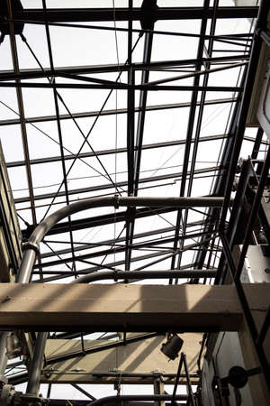 An interior view looking up at a large window pane structure inside an industrial building.の写真素材