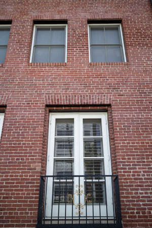 A vertical view of an exterior wall of a building in brick with windows.の写真素材