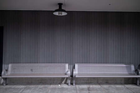 A front view looking at two aluminum benches outside of a building in the city.の写真素材