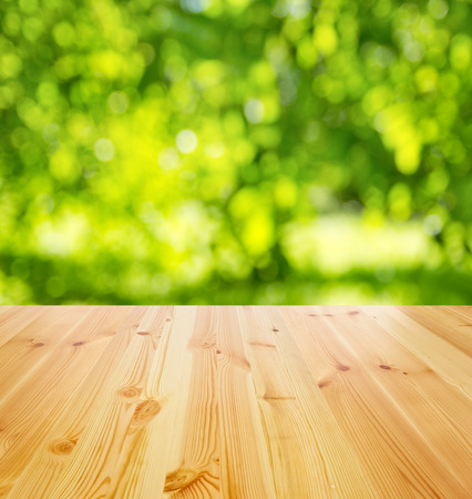empty wooden table against sunny garden for backgroundの写真素材