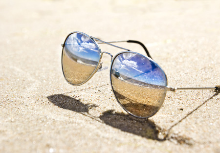 sea landscape reflecting in the sunglasses on the beachの写真素材